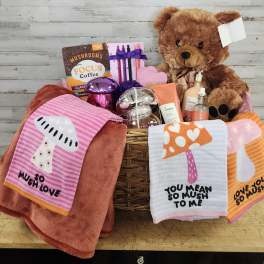 Gift basket with a teddy bear, coffee, skincare items, and mushroom-themed towels