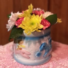 Small mixed flower arrangement in a painted ceramic mug