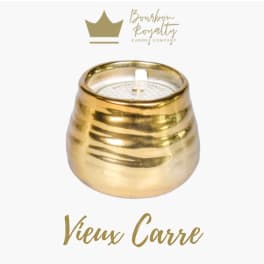 Gold candle in a rounded metallic holder with a white wick