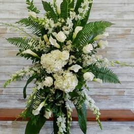 Tall white floral standing arrangement with calla lilies and roses