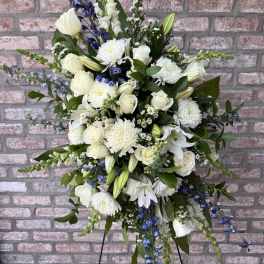 Large white and blue floral standing arrangement on a black easel
