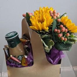 Sunflower bouquet with berries and a coffee cup in a gift box
