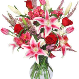 Bouquet of pink lilies and red roses in a glass vase