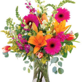 Bright mixed bouquet with orange lilies and pink gerbera daisies in a clear vase
