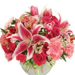 Pink lilies and roses arranged in a round vase