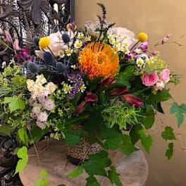 Mixed bouquet with orange, pink, purple, and white flowers in a vase