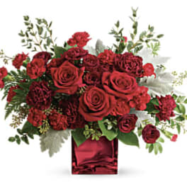 Red roses and carnations in a red glass vase