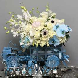 Blue and white floral arrangement in a decorative metal cart