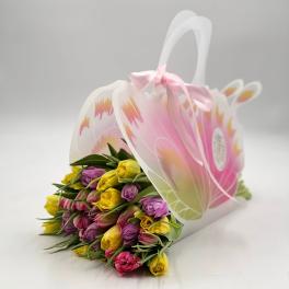 Bouquet of pink, yellow, and purple tulips in a decorative gift bag