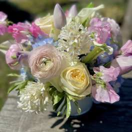 Pastel bouquet with roses, ranunculus, and mixed blooms in a vase