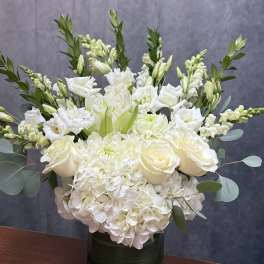 White floral arrangement in a dark green vase