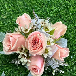 Small pink rose bouquet with white filler flowers and a blue ribbon