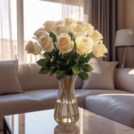 Cream-colored roses in a clear glass vase on a table