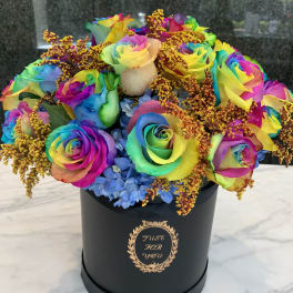 Rainbow roses in a black hatbox with blue hydrangeas