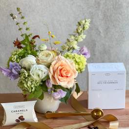 Mixed bouquet in a white vase with coffee and caramel gift items