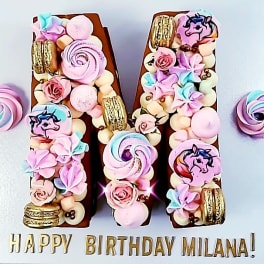 Birthday cake decorated with pastel unicorn and candy toppers
