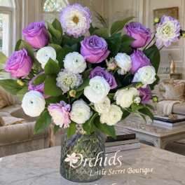 Purple and white flower arrangement in a glass vase