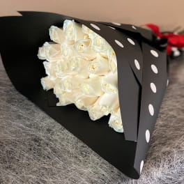 Bouquet of white roses wrapped in black paper with white polka dots