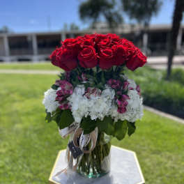Red roses and white hydrangeas in a glass vase