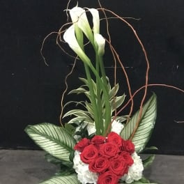 Red roses and white calla lilies in a tall floral arrangement