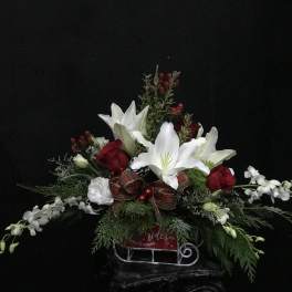 Holiday floral arrangement with white lilies, red roses, and a plaid ribbon