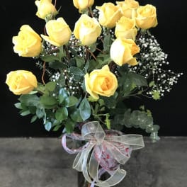 Bouquet of yellow roses with baby's breath in a glass vase