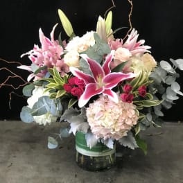 Pink lilies and hydrangeas in a glass vase