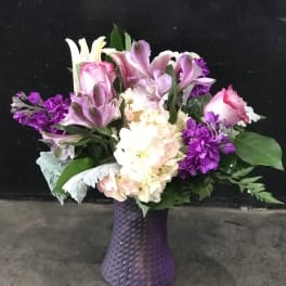 Purple and pink mixed bouquet in a textured purple vase