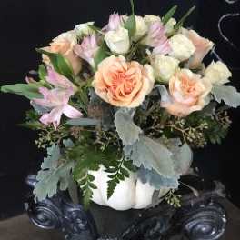 Peach and white roses with pink alstroemeria in a white pumpkin container