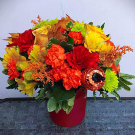 Bright autumn bouquet with red, orange, and yellow flowers in a red vase