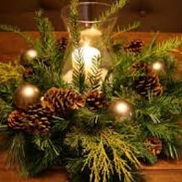 Pine and pinecone centerpiece with a candle in a glass holder