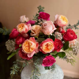 Bouquet of pink and peach roses in a white vase