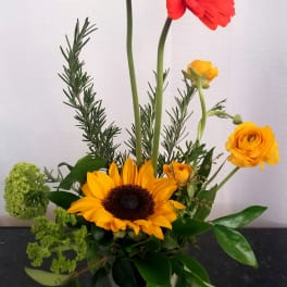 Mixed bouquet with red and yellow gerbera daisies in a glass vase
