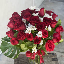 Bouquet of red roses and white daisies in a glass vase