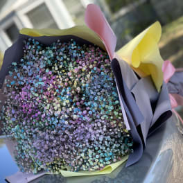 Bouquet of tiny multicolored flowers wrapped in pastel paper