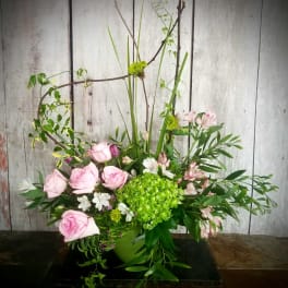 Pink roses and green hydrangea in a low vase arrangement