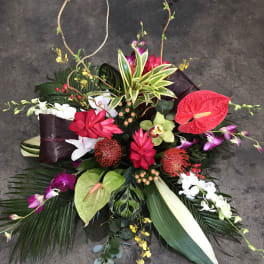 Tropical floral arrangement with anthuriums, orchids, and red blooms