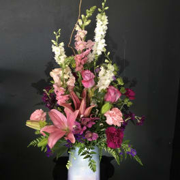 Tall pink and white floral arrangement in a pastel vase