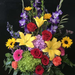Colorful mixed flower arrangement with roses, lilies, and sunflowers