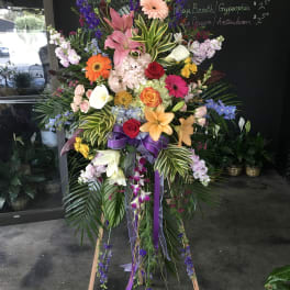 Tall standing floral spray with lilies, roses, gerberas, and orchids