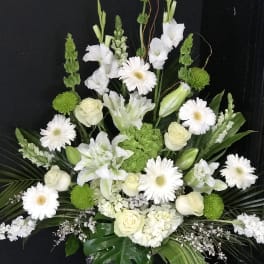 White and green floral arrangement with roses and daisies in a vase