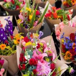 Assorted colorful bouquets wrapped in brown paper