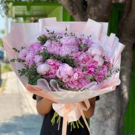 Large bouquet of pink peonies wrapped in pale pink paper