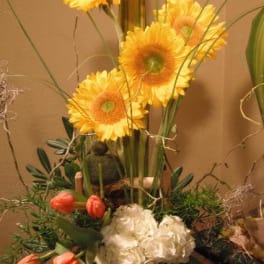 Tall floral arrangement with yellow gerbera daisies and coral tulips