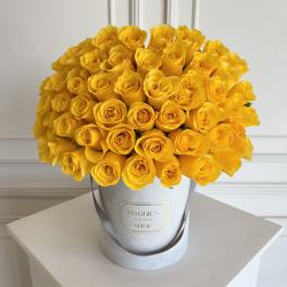 Bouquet of bright yellow roses in a silver hat box