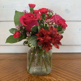 Pink and red mixed flower bouquet in a glass vase