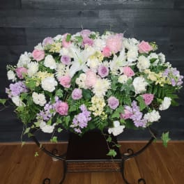 Large pastel floral arrangement with pink and lavender roses and white lilies