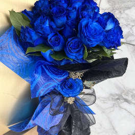 Bouquet of vivid blue roses wrapped in blue and black paper