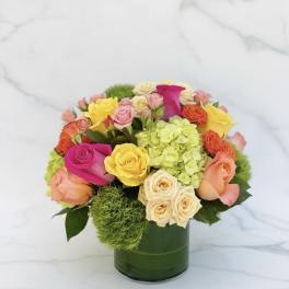 Colorful rose bouquet in a green glass vase