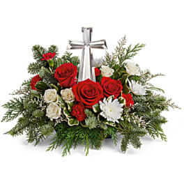 Red and white roses arranged around a silver cross